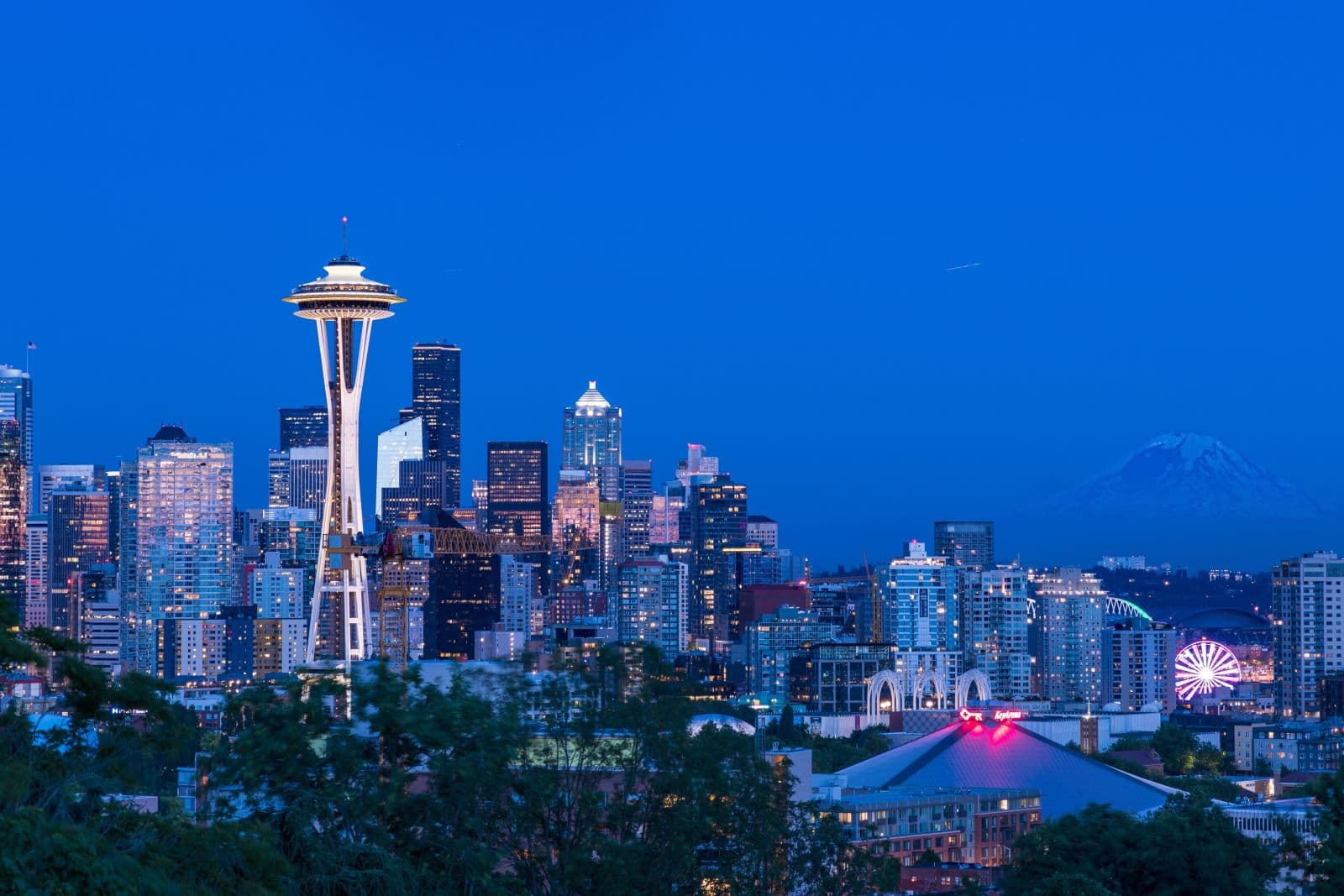 Canadian couple reviewing property plans while preparing to buy property in Washington with a Seattle skyline in the background.